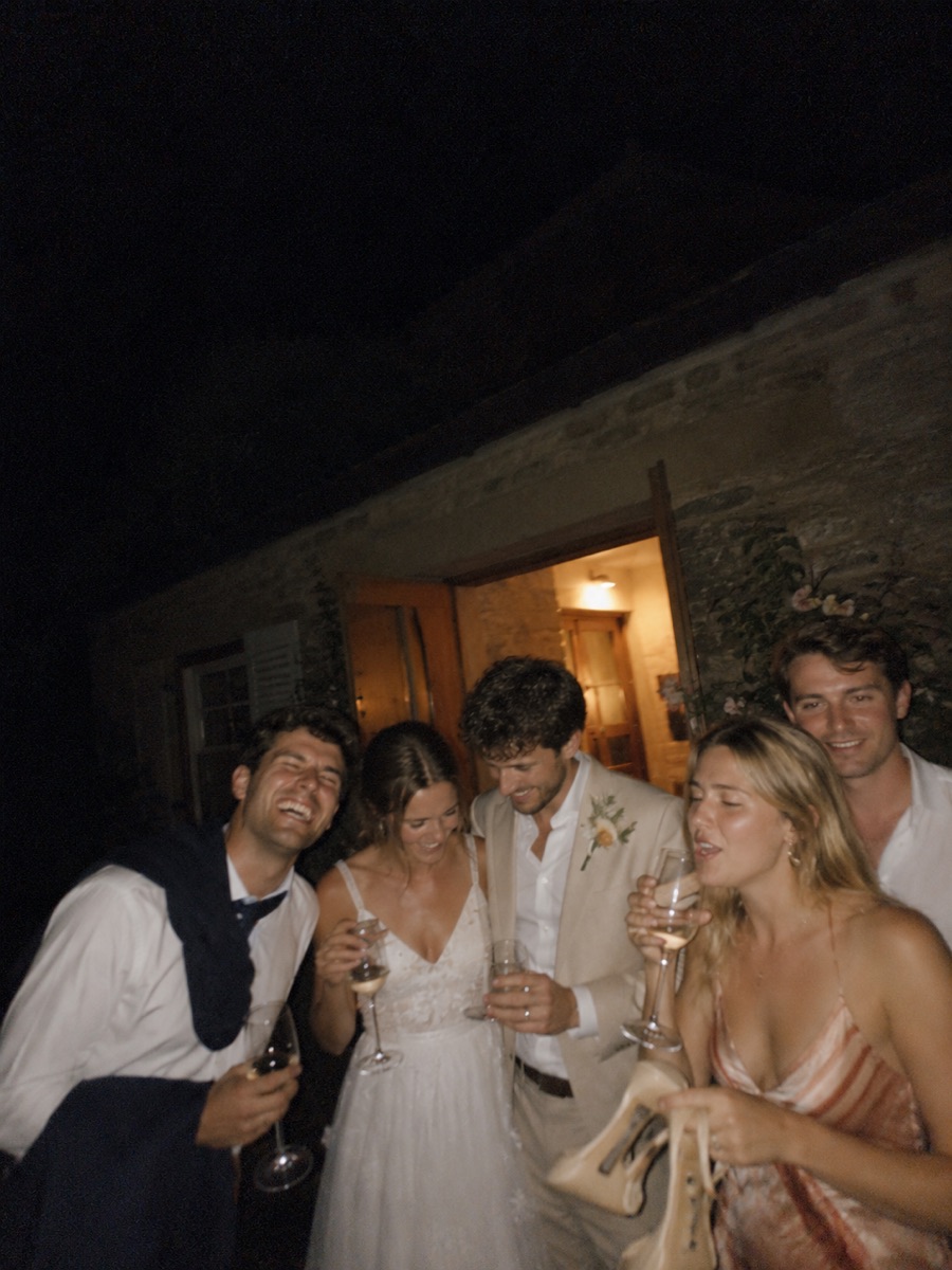The couple and a few guests outside a venue late at night